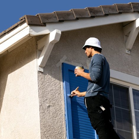 Man Painting the Window Shutter