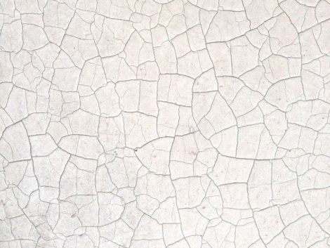 a close up of a white wall with cracks in it